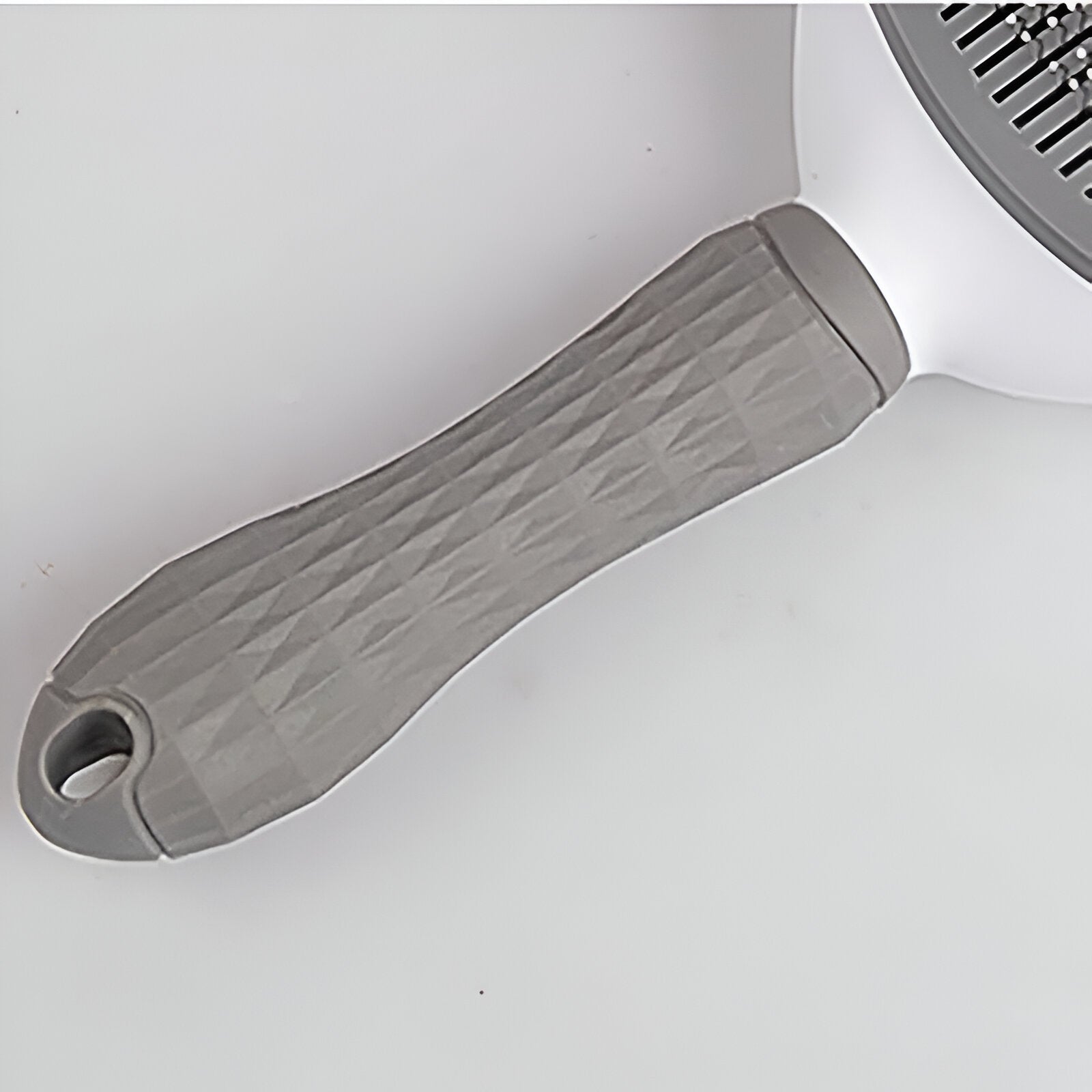 poignée de la brosse pour chien de couleur blanc et gris. Image produit Boutiquechien