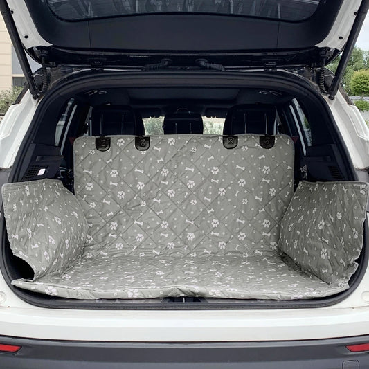 protection de coffre de voiture de couleur noir. La protection est de couleur grise avec des formes de pattes et os dans une voiture de couleur grise. Image produit Boutiquechien