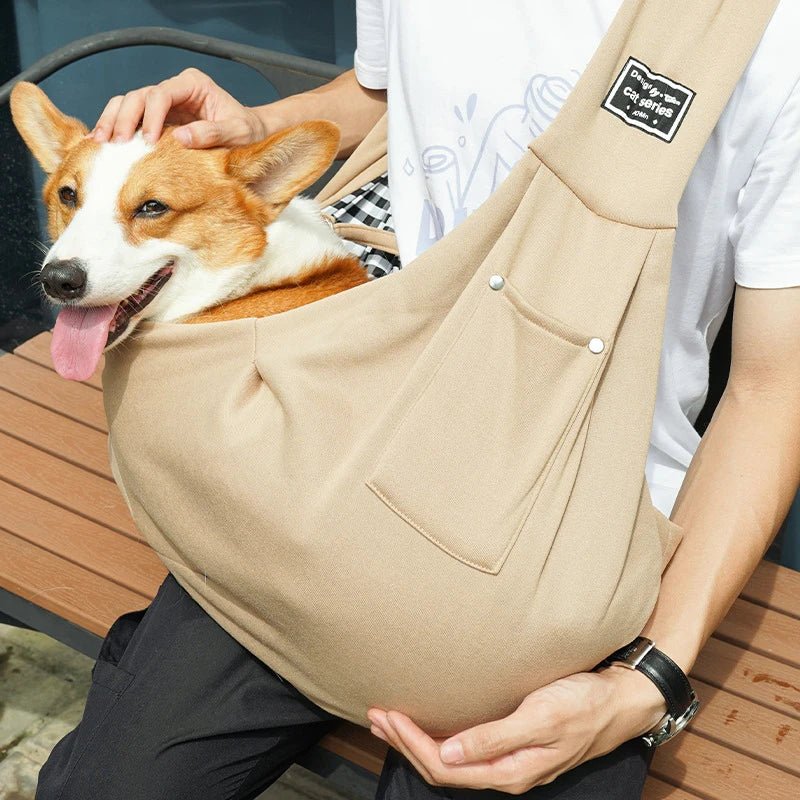 sac beige pour chien en bandoulière avec un chien moyen de couleur brun et blanc. Le chien est maintenu par son maître habillé avec un t-shirt blanc et un pantalon noir. Image produit Boutiquechien