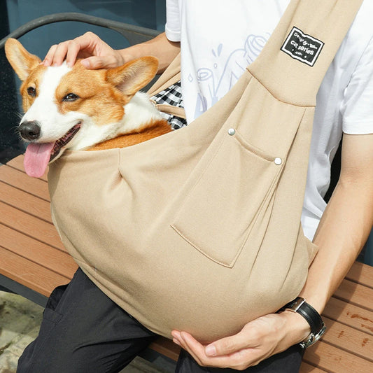 sac beige pour chien en bandoulière avec un chien moyen de couleur brun et blanc. Le chien est maintenu par son maître habillé avec un t-shirt blanc et un pantalon noir. Image produit Boutiquechien