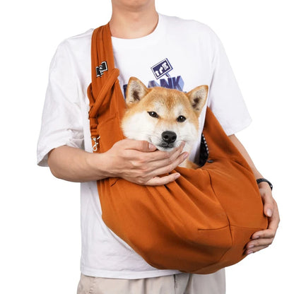Sac pour chien brun claire porté par un homme habille en blanc avec un short claire. Le sac pour chien est de couleur noir avec une attache dans le sac. Image produit Boutiquechien