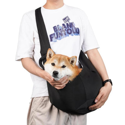 Sac pour chien noir porté par un homme habille en blanc avec un short claire. Le sac pour chien est de couleur noir avec une attache dans le sac. Image produit Boutiquechien