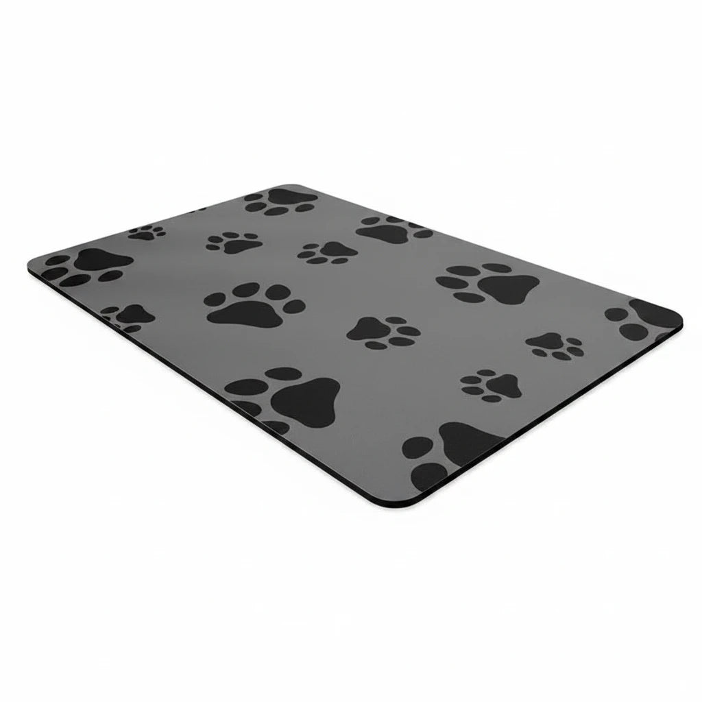 Tapis à gamelle pour chien de couleur gris avec des pattes de chien de couleur noir. Le tapis chien est posé sur un sol claire. Image produit Boutiquechien