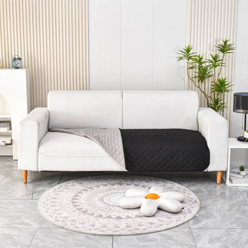 Tapis chien noir canapé lavable protégeant un canapé blanc. le canapé blanc est dans un salon de couleur blanc avec sur le côté une table basse. image produit Boutiquechien