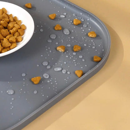 Tapis de protection pour chien de couleur gris avec des croquettes et de l'eau dessus pour montrer la résistance. Image produit Boutiquechien