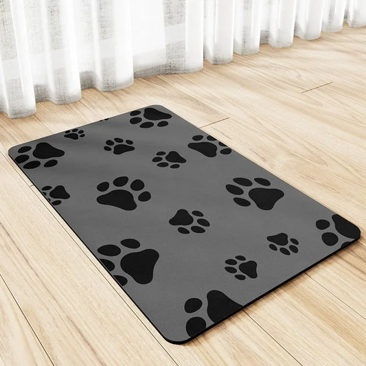 Tapis à gamelle pour chien de couleur gris avec des pattes de chien de couleur noir. Le tapis chien est posé sur un sol claire. Image produit Boutiquechien